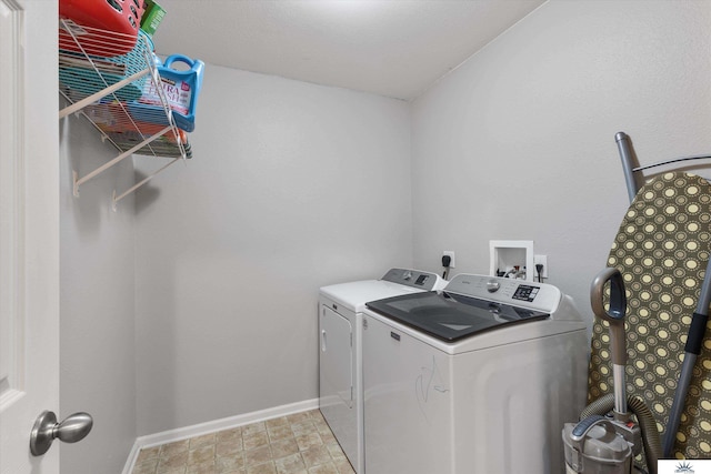 laundry area featuring baseboards, separate washer and dryer, and laundry area