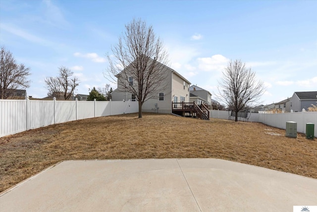 view of yard with a deck, a patio area, and a fenced backyard