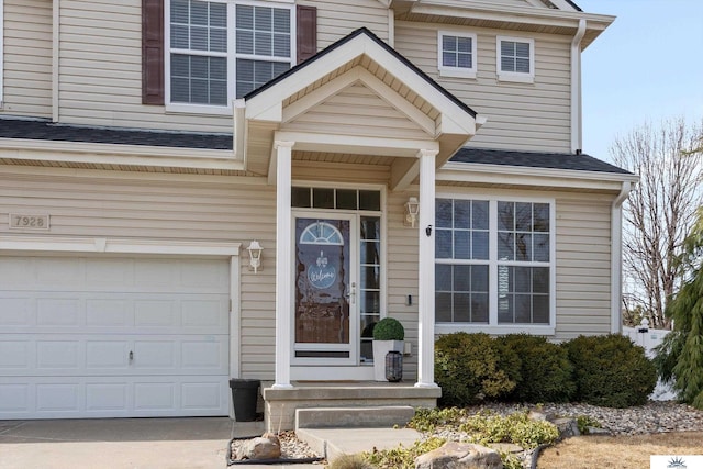 doorway to property with a garage and roof with shingles