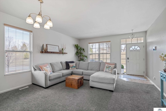 carpeted living room featuring visible vents, baseboards, and an inviting chandelier