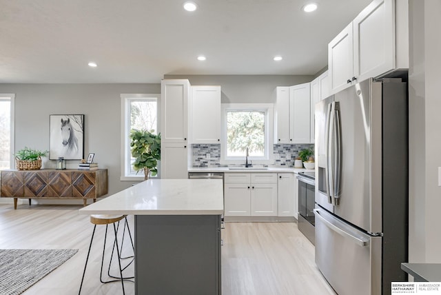 kitchen with a center island, a healthy amount of sunlight, appliances with stainless steel finishes, and a sink