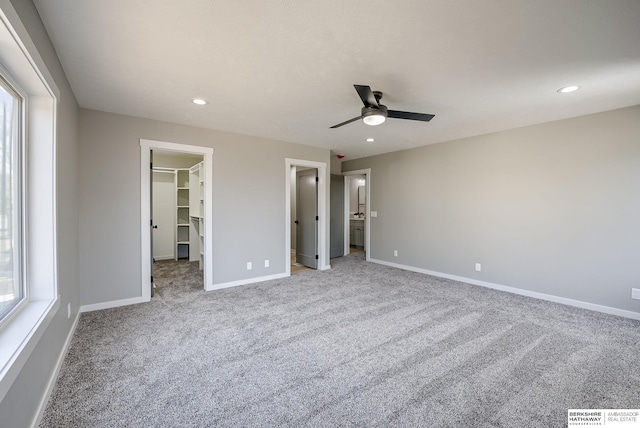 unfurnished bedroom featuring a spacious closet, carpet, baseboards, recessed lighting, and a closet