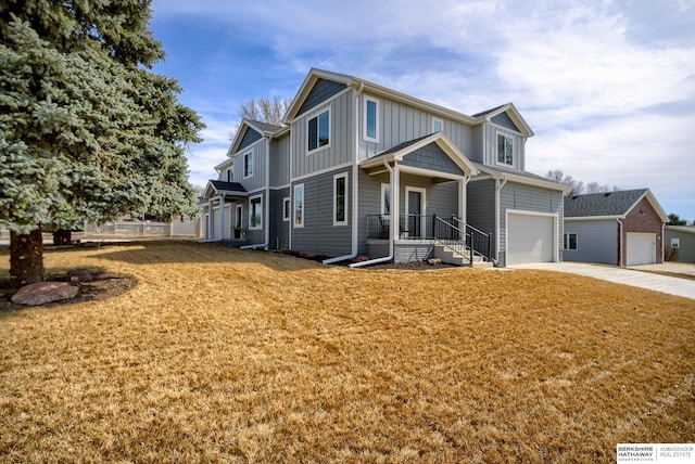 view of front of home featuring an attached garage, board and batten siding, concrete driveway, and a front yard