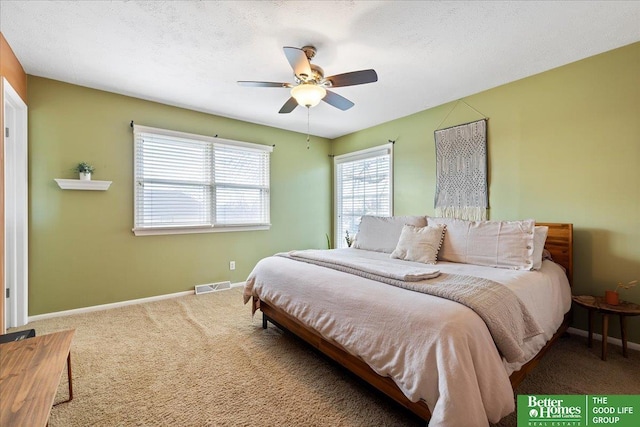 carpeted bedroom featuring visible vents, baseboards, a textured ceiling, and ceiling fan