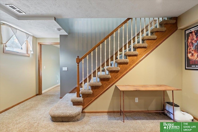 stairway with visible vents, carpet floors, a textured ceiling, and baseboards