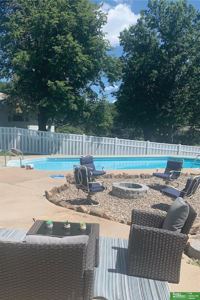 view of swimming pool with a fenced in pool, a patio area, a fenced backyard, and an outdoor fire pit