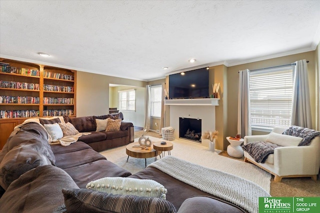 carpeted living area featuring a textured ceiling, a fireplace with flush hearth, baseboards, and ornamental molding