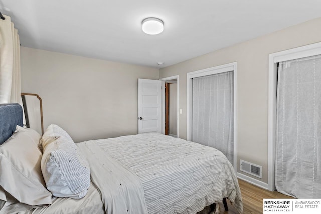 bedroom featuring visible vents and wood finished floors