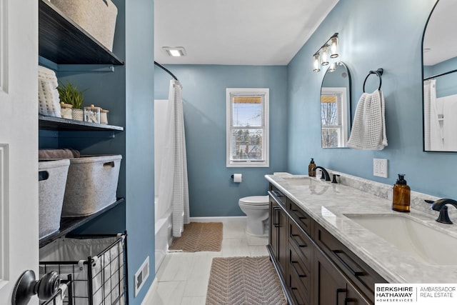 full bath with baseboards, visible vents, double vanity, a sink, and toilet