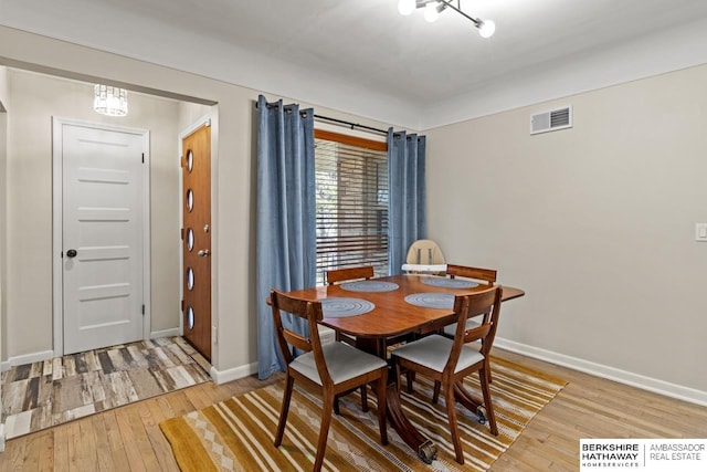 dining area with visible vents, light wood-type flooring, and baseboards