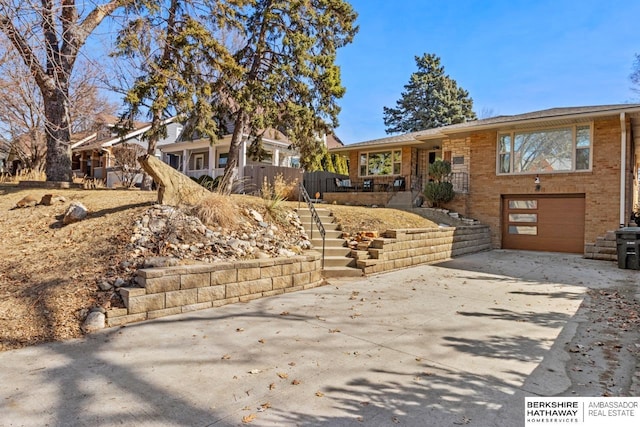 ranch-style house with concrete driveway, an attached garage, and brick siding