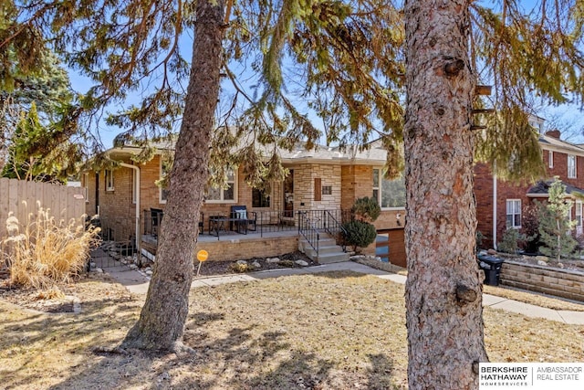 view of front of home featuring fence and brick siding