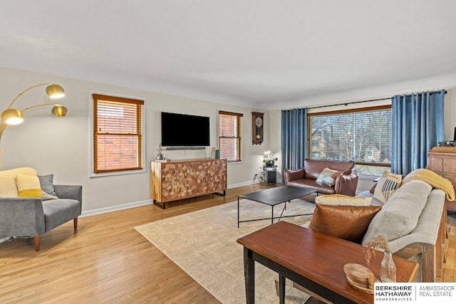 living area featuring baseboards and light wood-style flooring