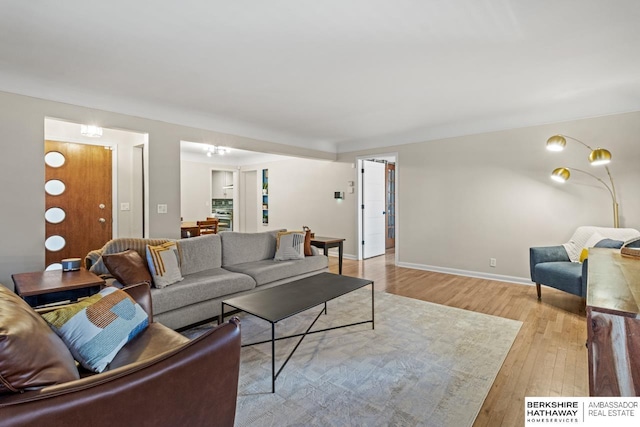 living area with light wood-type flooring and baseboards