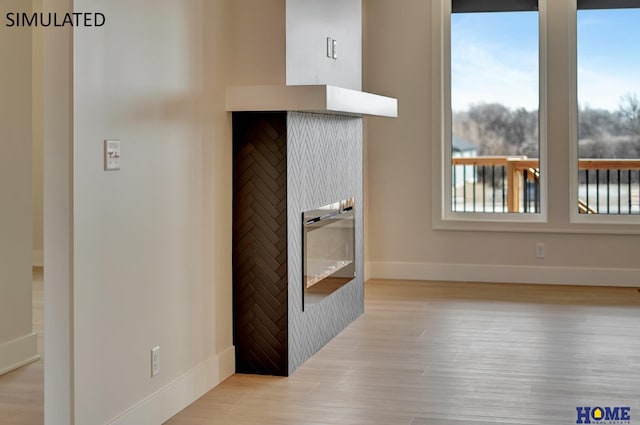 interior space with a fireplace, wood finished floors, and baseboards