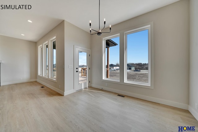 unfurnished dining area featuring a chandelier, visible vents, baseboards, and wood finished floors