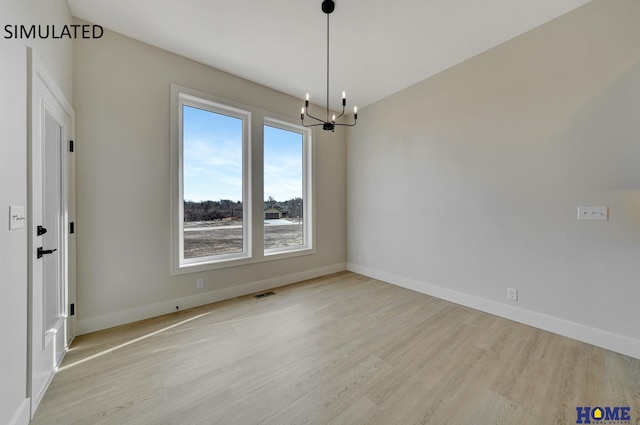 empty room featuring visible vents, baseboards, and light wood finished floors