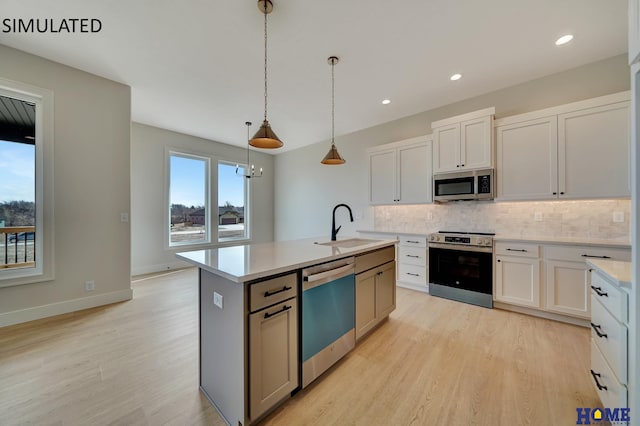 kitchen with a sink, decorative backsplash, appliances with stainless steel finishes, and light countertops