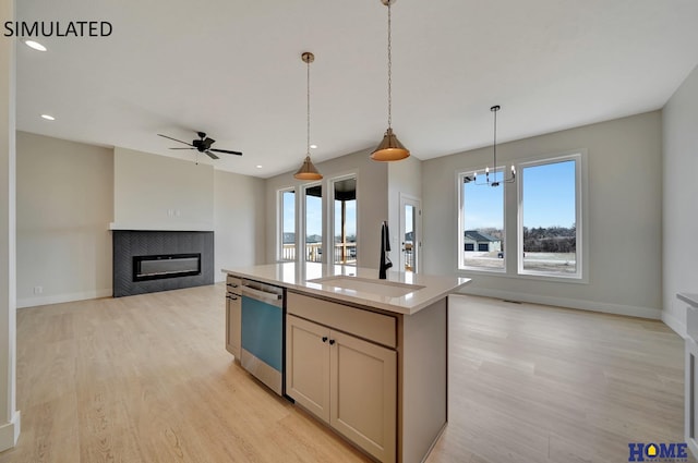 kitchen featuring dishwashing machine, a tile fireplace, open floor plan, and a sink