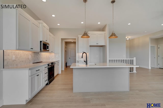 kitchen with light wood-style flooring, a sink, white cabinets, electric stove, and stainless steel microwave