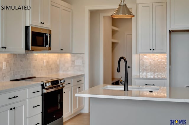 kitchen with white cabinets, pendant lighting, and stainless steel appliances