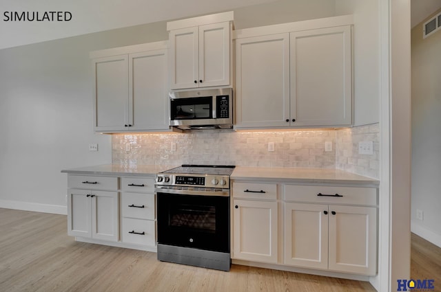 kitchen with light wood-style floors, stainless steel appliances, baseboards, and backsplash