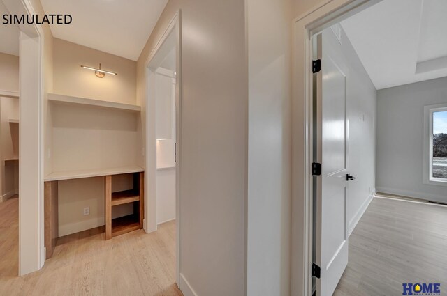 corridor featuring baseboards and wood finished floors