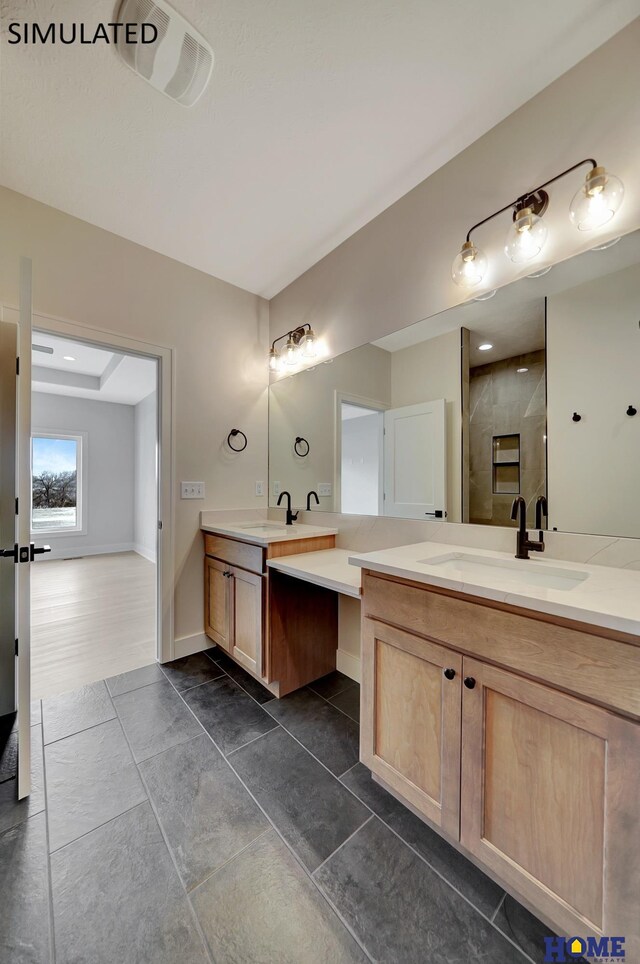 full bathroom featuring a shower stall, two vanities, baseboards, and a sink