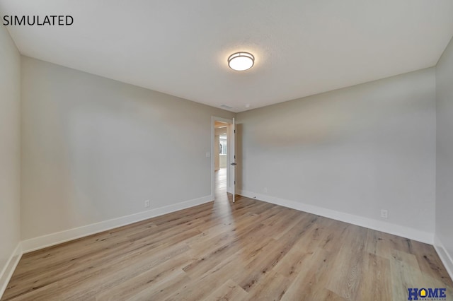 spare room featuring wood finished floors and baseboards