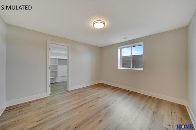 spare room with visible vents, wood finished floors, and baseboards