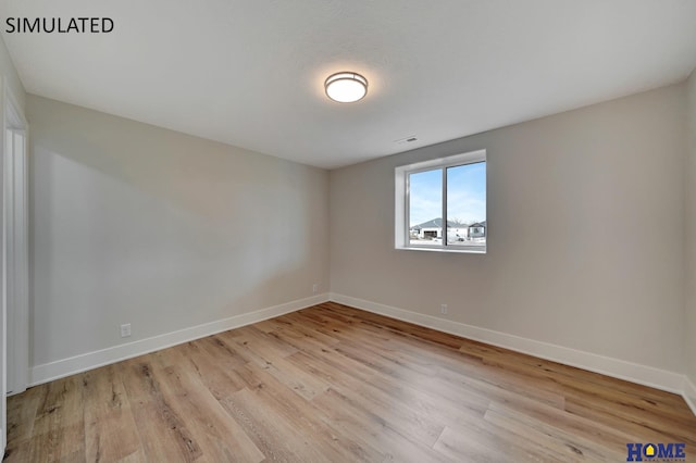 unfurnished room with visible vents, baseboards, and light wood finished floors