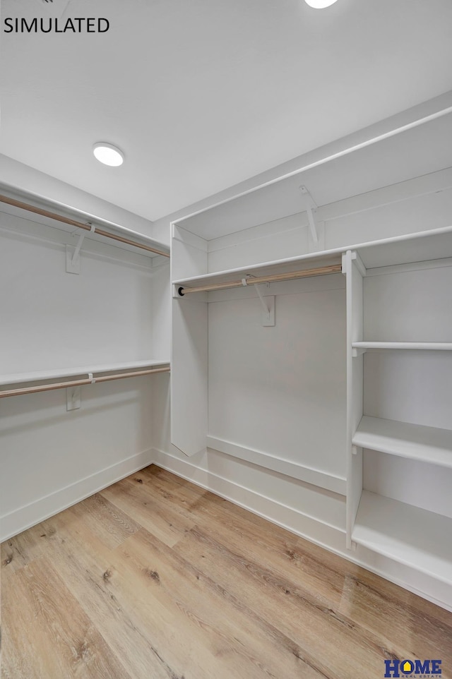 walk in closet with wood finished floors