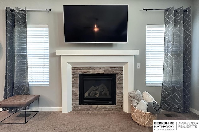 living area with a wealth of natural light, carpet flooring, and a fireplace