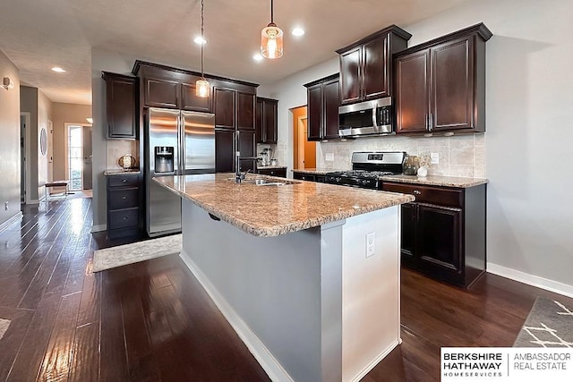 kitchen with tasteful backsplash, dark wood-type flooring, dark brown cabinetry, appliances with stainless steel finishes, and a sink