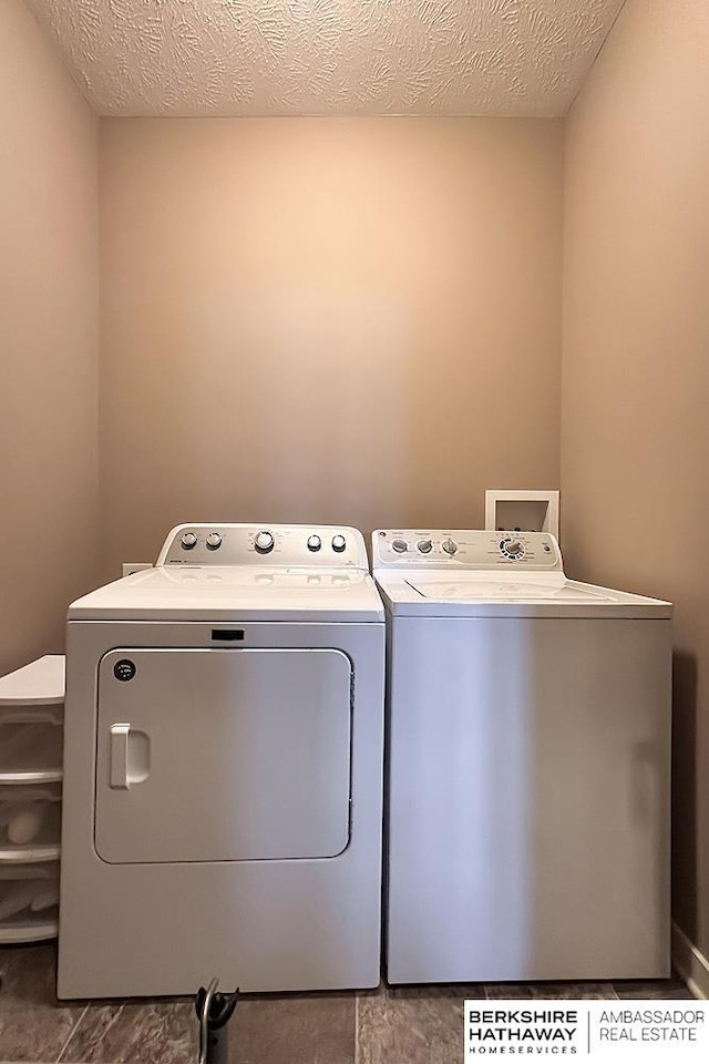 laundry room with laundry area, a textured ceiling, and separate washer and dryer