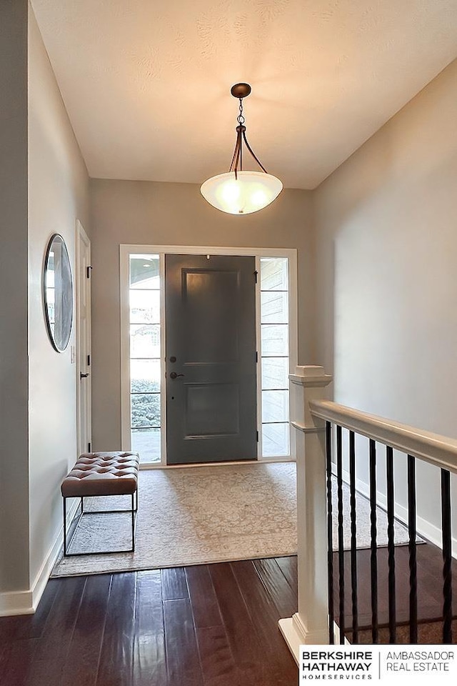 entryway with baseboards and dark wood-style floors