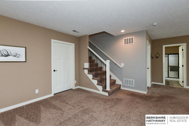 staircase with visible vents, baseboards, and carpet