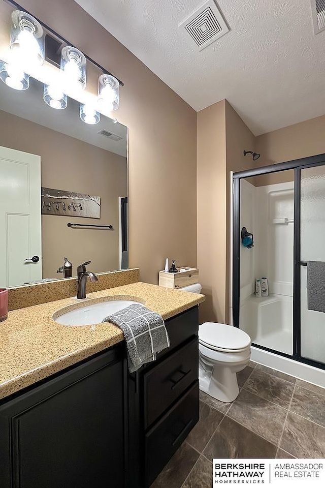 full bathroom with vanity, visible vents, a stall shower, a textured ceiling, and toilet