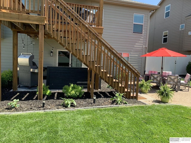 back of property with stairway, a lawn, a wooden deck, and a patio area