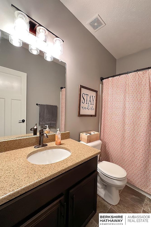 full bathroom with vanity, visible vents, tile patterned flooring, a textured ceiling, and toilet