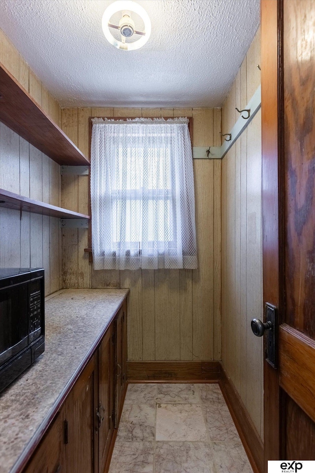 interior space with wooden walls and a textured ceiling