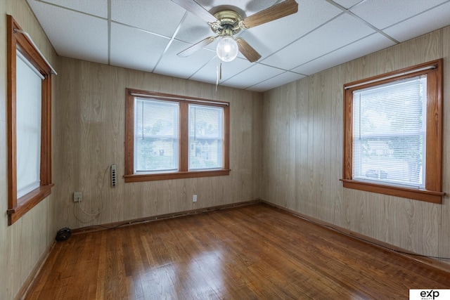 spare room with a paneled ceiling, ceiling fan, and wood finished floors