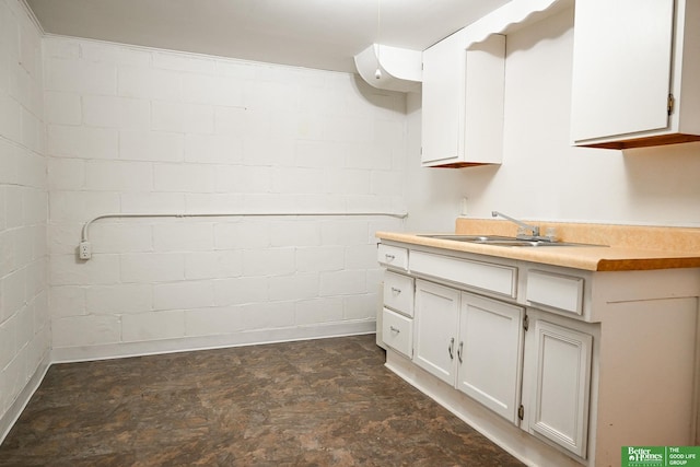 interior space featuring a sink, white cabinets, and light countertops