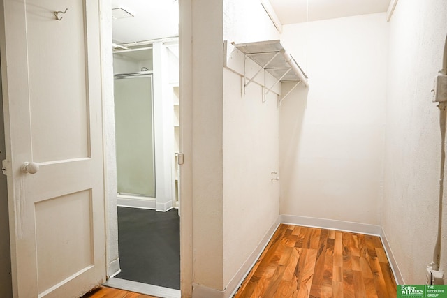 walk in closet with wood finished floors