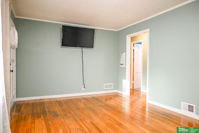 spare room featuring crown molding, visible vents, and wood-type flooring