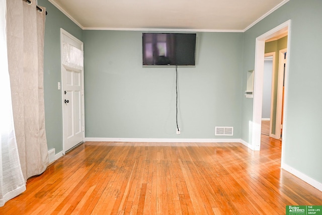 unfurnished room featuring visible vents, wood-type flooring, baseboards, and crown molding