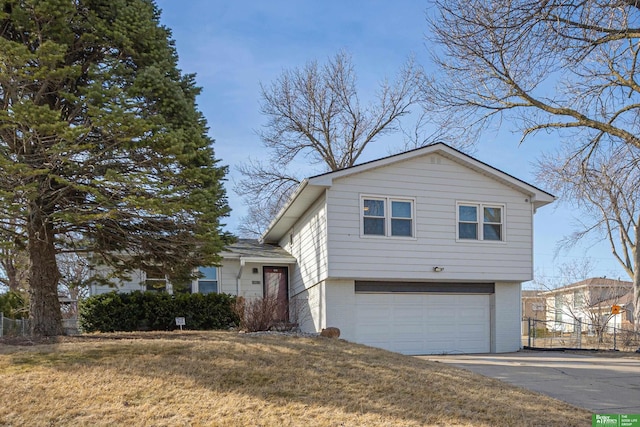 tri-level home featuring brick siding, an attached garage, concrete driveway, and a front yard