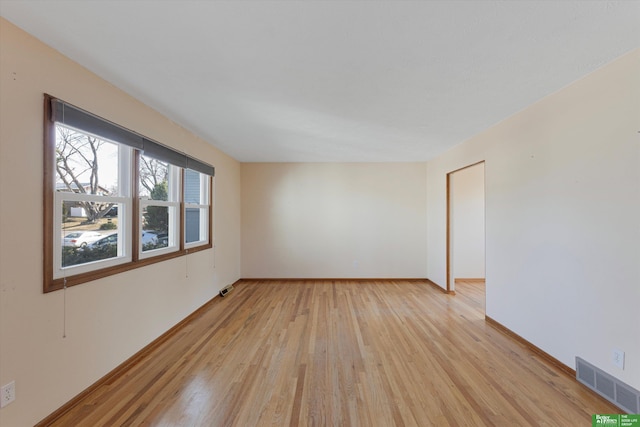 empty room featuring visible vents, baseboards, and light wood-style floors