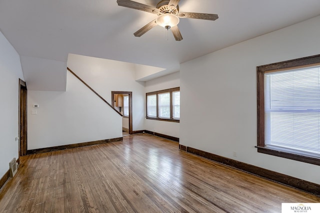 unfurnished living room featuring visible vents, a ceiling fan, baseboards, and wood finished floors