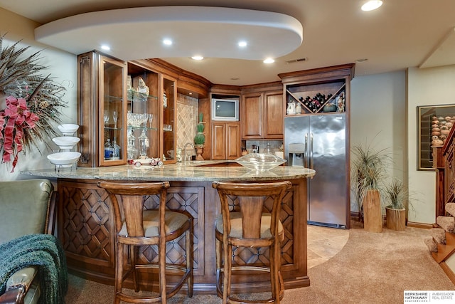 bar featuring visible vents, wet bar, recessed lighting, light colored carpet, and stainless steel fridge